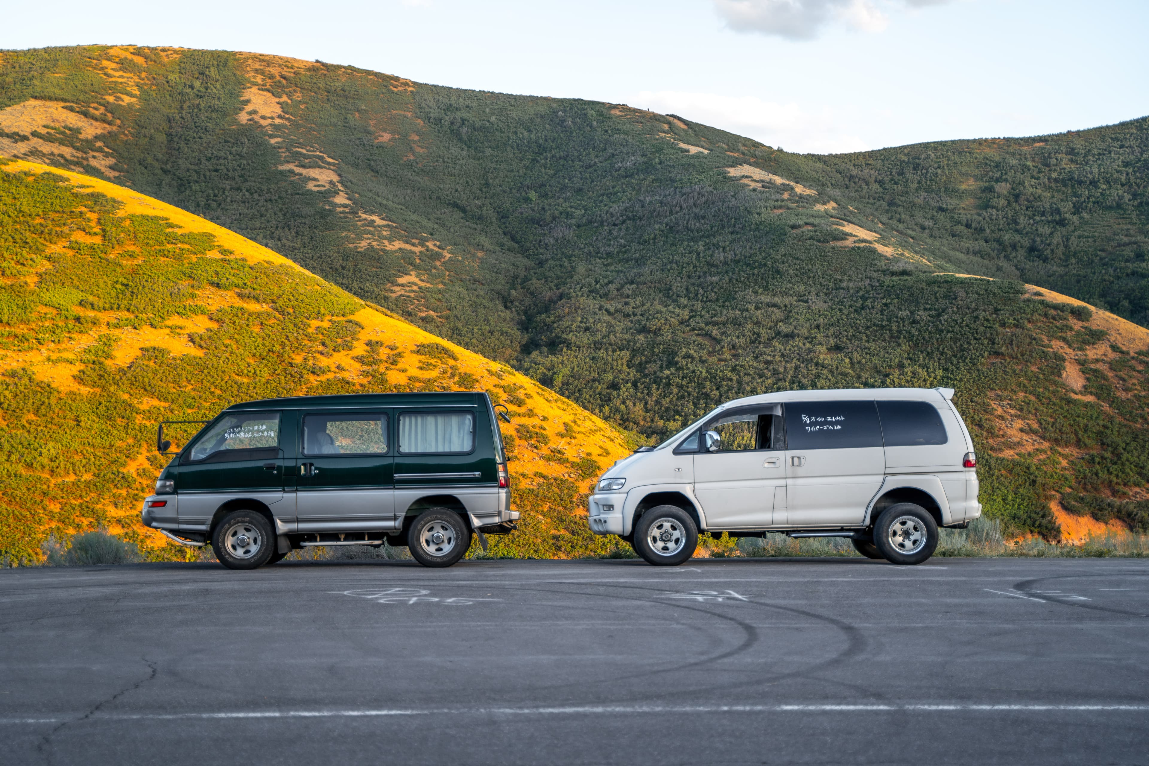 Green 1999 Mitsubishi Delica Star Wagon and white 1999 Mitsubishi Delica Space Gear